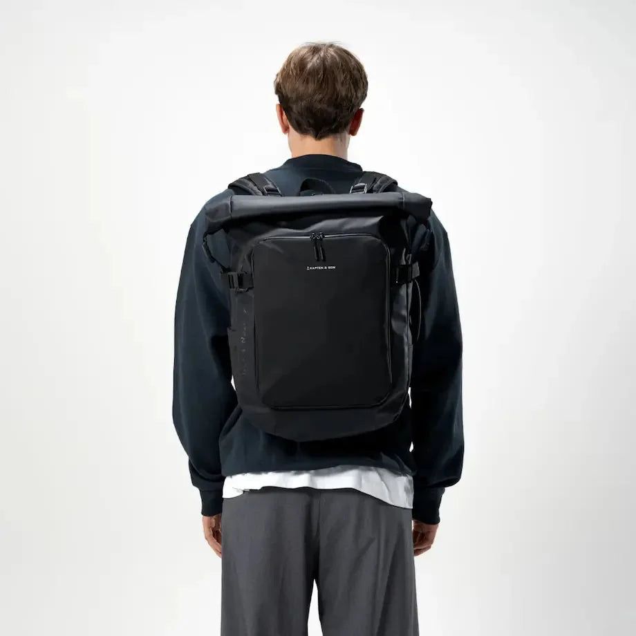 Man wearing the Lisbon Pro black backpack — rear view