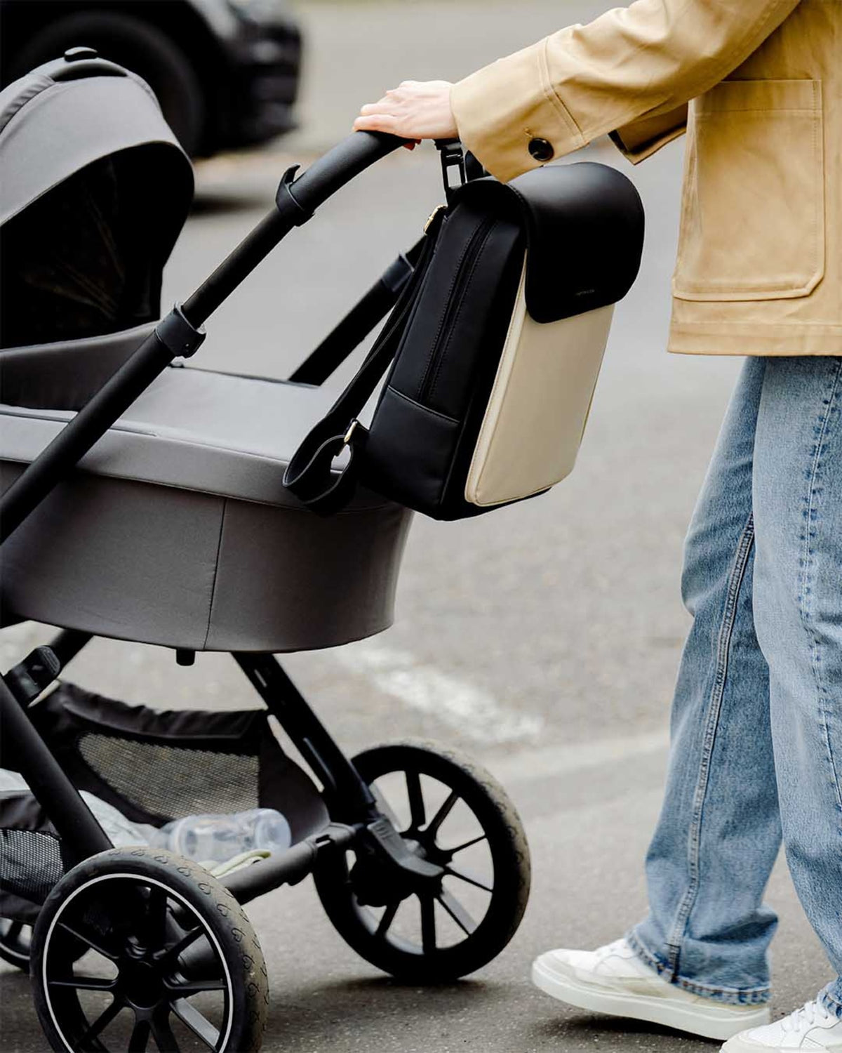 The cream black Kapten & Son Tromso hanging from a buggy handlebar