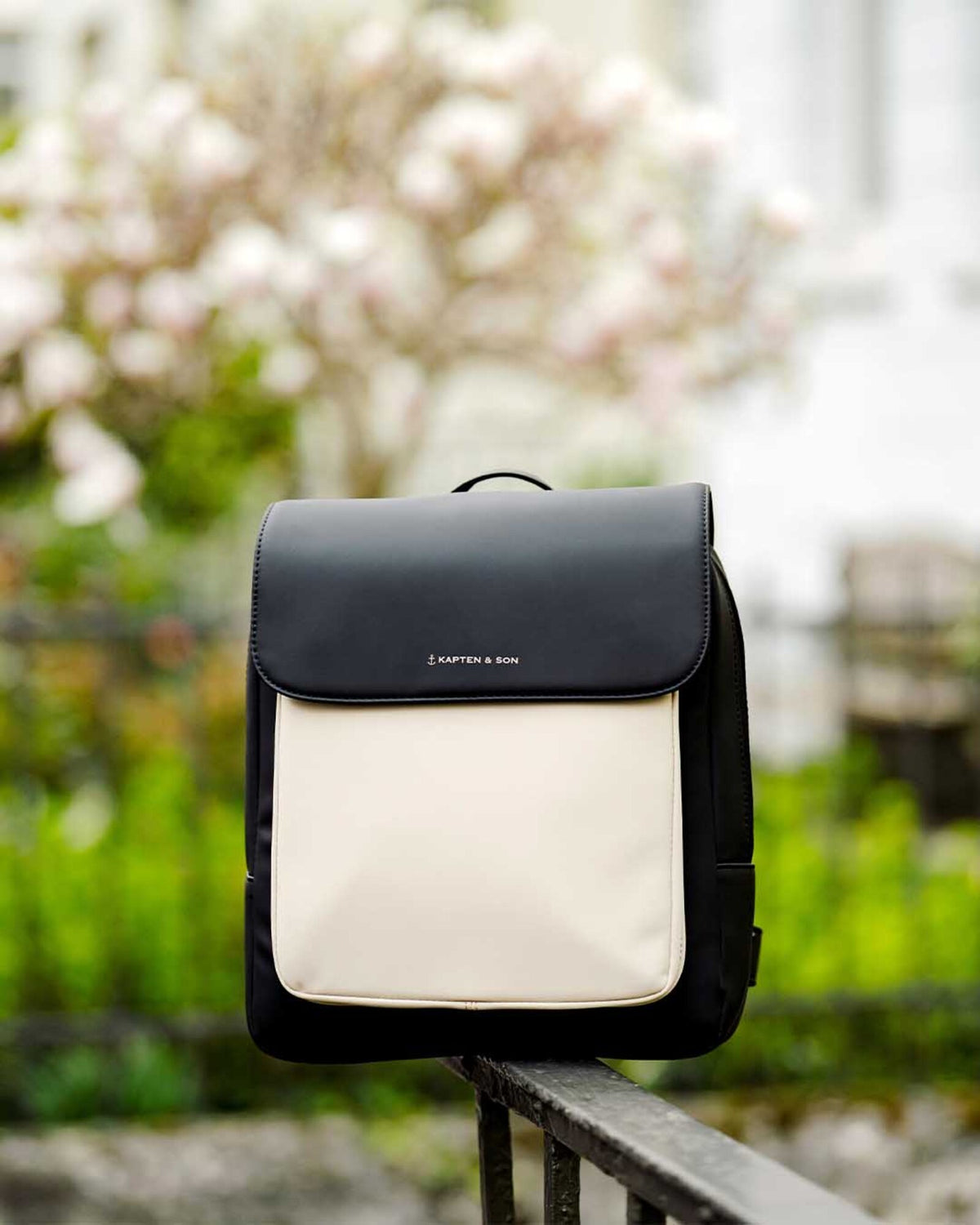 The cream black Kapten & Son Tromso Small on a railing, magnolias behind