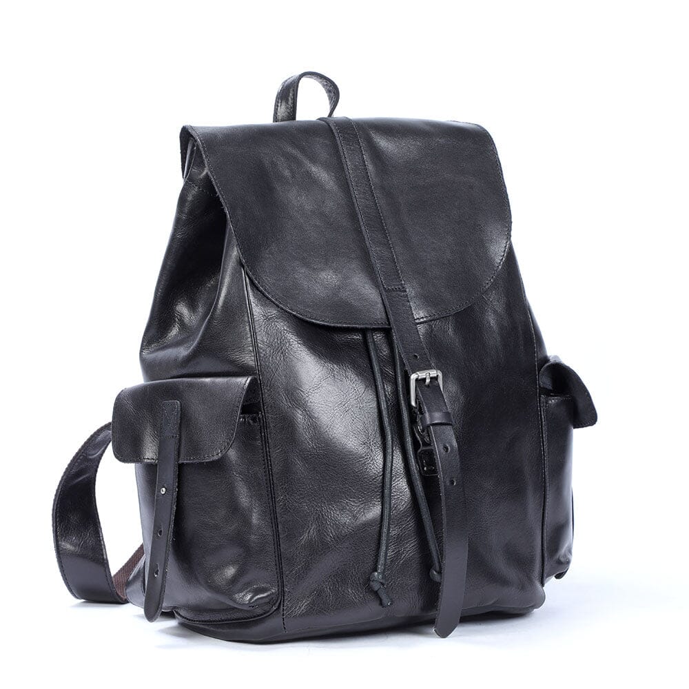 dreiviertelansicht des schwarzen lederrucksacks, seitliche klappentasche und mittelriemen