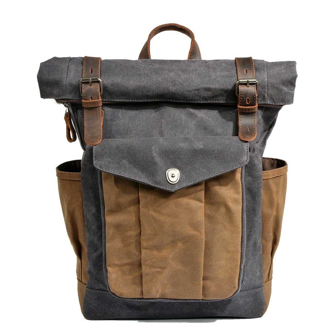 Waxed canvas roll top backpack in dark grey with crazy horse leather strap closures, brass buckles and tan contrast canvas front pocket — Lund